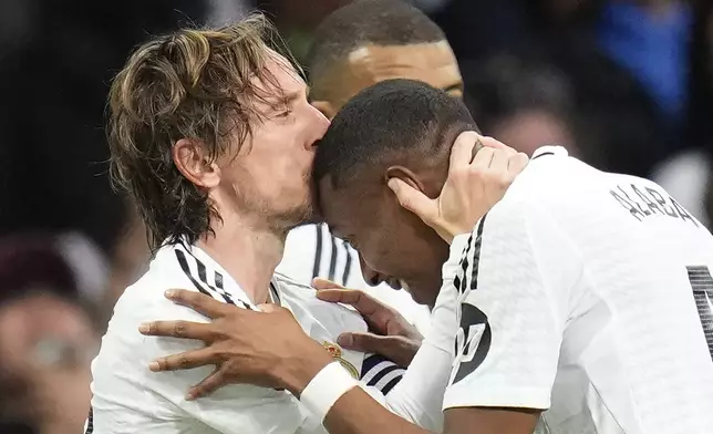 Real Madrid's Luka Modric, left, celebrates with David Alaba, right, after scoring the opening goal during the Spanish La Liga soccer match between Real Madrid and Girona at the Santiago Bernabeu stadium in Madrid, Spain, Sunday, Feb. 23, 2025. (AP Photo/Manu Fernandez)