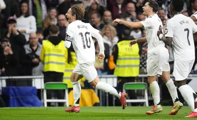 Real Madrid's Luka Modric, left, celebrates after scoring the opening goal during the Spanish La Liga soccer match between Real Madrid and Girona at the Santiago Bernabeu stadium in Madrid, Spain, Sunday, Feb. 23, 2025. (AP Photo/Manu Fernandez)