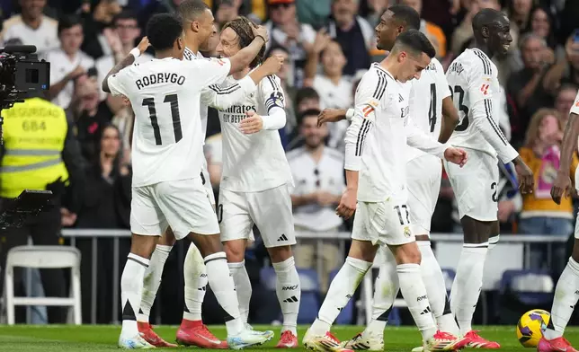 Real Madrid's Luka Modric, third from left, celebrates with teammates after scoring the opening goal during the Spanish La Liga soccer match between Real Madrid and Girona at the Santiago Bernabeu stadium in Madrid, Spain, Sunday, Feb. 23, 2025. (AP Photo/Manu Fernandez)