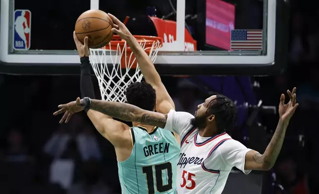 Charlotte Hornets guard Josh Green (10) drives for a dunk against Los Angeles Clippers forward Derrick Jones Jr. (55) during the first half of an NBA basketball game in Charlotte, N.C., Friday, Jan. 31, 2025. (AP Photo/Nell Redmond)
