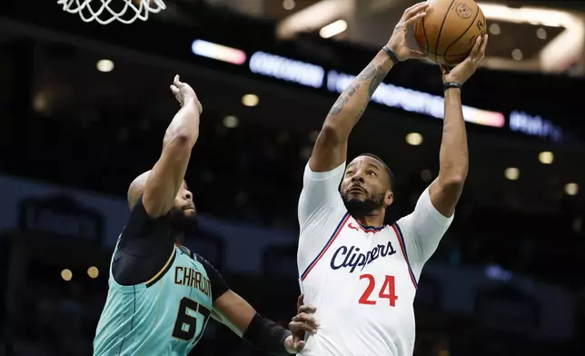 Los Angeles Clippers guard Norman Powell (24) shoots over Charlotte Hornets forward Taj Gibson, left, during the first half of an NBA basketball game in Charlotte, N.C., Friday, Jan. 31, 2025. (AP Photo/Nell Redmond)