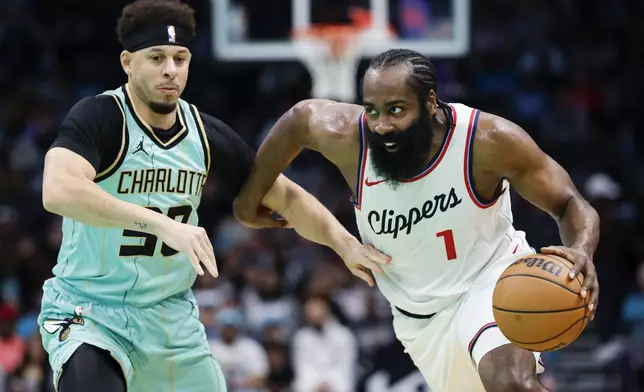 Los Angeles Clippers guard James Harden (1) drives past Charlotte Hornets guard Seth Curry, left, during the first half of an NBA basketball game in Charlotte, N.C., Friday, Jan. 31, 2025. (AP Photo/Nell Redmond)
