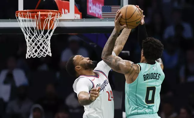 Charlotte Hornets forward Miles Bridges (0) looks to shoot against Los Angeles Clippers guard Norman Powell, left, during the first half of an NBA basketball game in Charlotte, N.C., Friday, Jan. 31, 2025. (AP Photo/Nell Redmond)