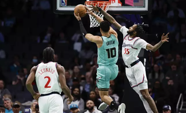Charlotte Hornets guard Josh Green (10) drives to the basket against Los Angeles Clippers forward Derrick Jones Jr. (55) as Clippers forward Kawhi Leonard watches during the first half of an NBA basketball game in Charlotte, N.C., Friday, Jan. 31, 2025. (AP Photo/Nell Redmond)