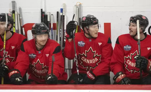 CORRECTS LOCATION TO BROSSARD NOT MONTREAL Canada players, from left, Connor McDavid, Sam Reinhart, Nathan MacKinnon and Sidney Crosby talk on the bench during 4 Nations Face-Off hockey practice in Brossard, Quebec on Monday, Feb. 10, 2025. Canada will face Sweden on Feb. 12. (Christinne Muschi/The Canadian Press via AP)