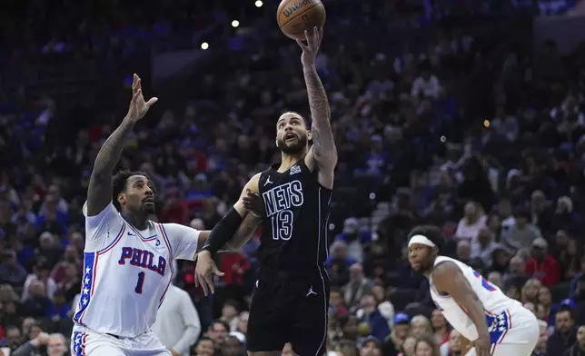 Brooklyn Nets' Tyrese Martin (13) goes up for a shot against Philadelphia 76ers' Andre Drummond (1) during the first half of an NBA basketball game, Saturday, Feb. 22, 2025, in Philadelphia. (AP Photo/Matt Slocum)