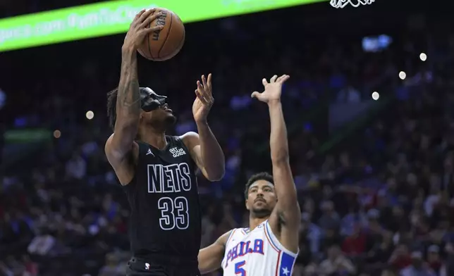 Brooklyn Nets' Nic Claxton (33) goes up for a shot against Philadelphia 76ers' Quentin Grimes (5) during the first half of an NBA basketball game, Saturday, Feb. 22, 2025, in Philadelphia. (AP Photo/Matt Slocum)
