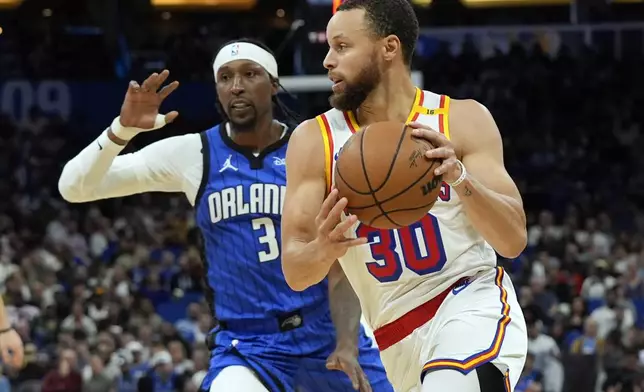 Golden State Warriors guard Stephen Curry (30) drives past Orlando Magic guard Kentavious Caldwell-Pope (3) during the second half of an NBA basketball game, Thursday, Feb. 27, 2025, in Orlando, Fla. (AP Photo/John Raoux)