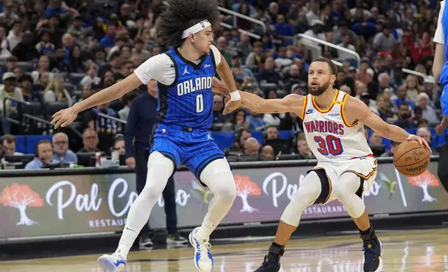 Golden State Warriors guard Stephen Curry (30) pulls up for a shot as Orlando Magic guard Anthony Black (0) tries to defend during the second half of an NBA basketball game, Thursday, Feb. 27, 2025, in Orlando, Fla. (AP Photo/John Raoux)