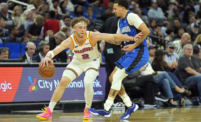 Golden State Warriors guard Brandin Podziemski (2) works to get around Orlando Magic guard Cole Anthony, right, during the first half of an NBA basketball game, Thursday, Feb. 27, 2025, in Orlando, Fla. (AP Photo/John Raoux)