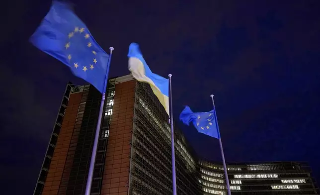 European Union and Ukrainian flags flap in the wind on the day to mark the third anniversary of Russia's full-scale invasion of Ukraine, at EU headquarters in Brussels, Monday, Feb. 24, 2025. (AP Photo/Virginia Mayo)