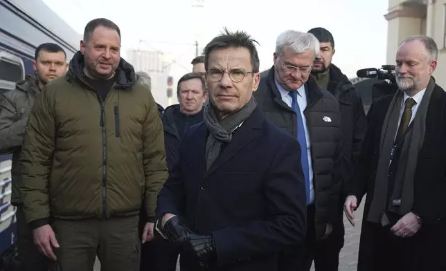 Sweden's Prime Minister Ulf Kristersson, center, arrives at a train station on the third anniversary of the Russian invasion of Ukraine, Kyiv, Ukraine, Monday, Feb. 24, 2025. (AP Photo/Efrem Lukatsky)