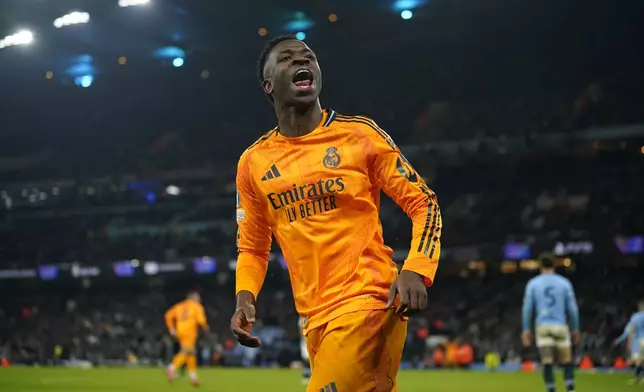 Real Madrid's Vinicius Junior celebrates after his teammate Real Madrid's Brahim Diaz scored their side second goal during the Champions League playoff first leg soccer match between Manchester City and Real Madrid at the Etihad Stadium in Manchester, England, Tuesday, Feb. 11, 2025. (AP Photo/Dave Thompson)