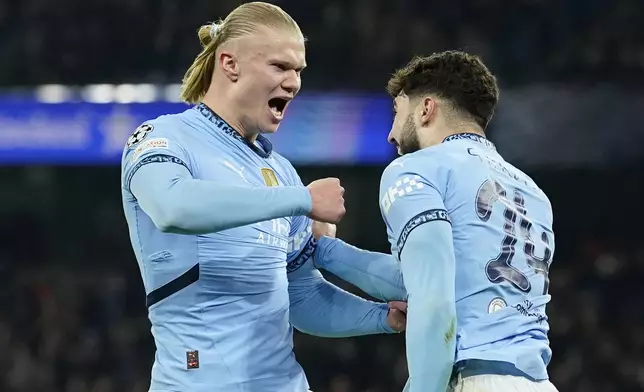 Manchester City's Erling Haaland, left, celebrates with Manchester City's Josko Gvardiol after scoring his sides first goal during the Champions League playoff first leg soccer match between Manchester City and Real Madrid at the Etihad Stadium in Manchester, England, Tuesday, Feb. 11, 2025. (AP Photo/Dave Thompson)