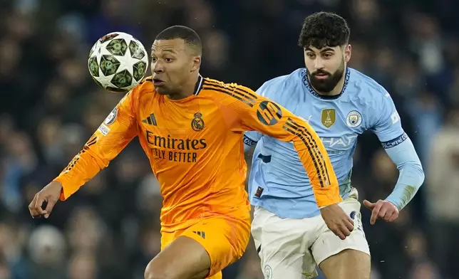 Manchester City's Josko Gvardiol, right, challenges Real Madrid's Kylian Mbappe during the Champions League playoff first leg soccer match between Manchester City and Real Madrid at the Etihad Stadium in Manchester, England, Tuesday, Feb. 11, 2025. (AP Photo/Dave Thompson)