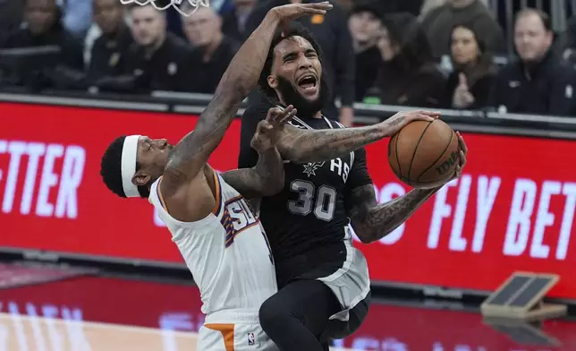 San Antonio Spurs forward Julian Champagnie (30) drives to the basket against Phoenix Suns guard Bradley Beal (3) during the first half of an NBA basketball game in Austin, Texas, Thursday, Feb. 20, 2025. (AP Photo/Eric Gay)