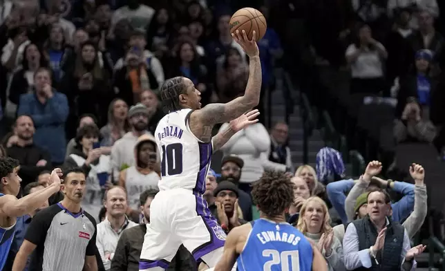 Sacramento Kings forward DeMar DeRozan (10) prepares to shoot and score in the final seconds of overtime as Dallas Mavericks' Kessler Edwards (20) looks on during an NBA basketball game in Dallas, Monday, Feb. 10, 2025. (AP Photo/Tony Gutierrez)
