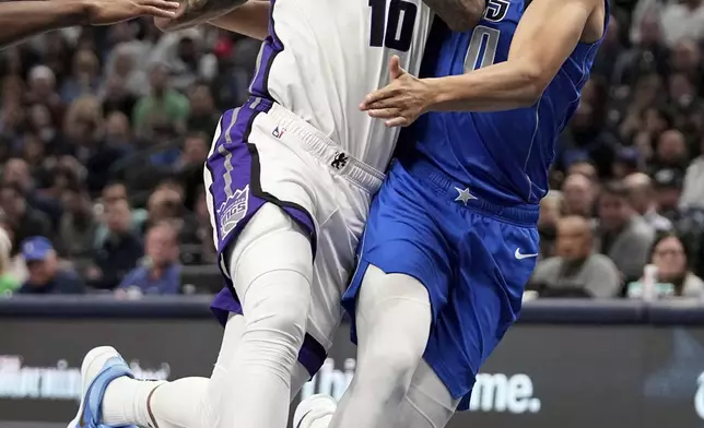 Sacramento Kings forward DeMar DeRozan (10) drives to the basket against Dallas Mavericks' Dante Exum (0) in the first half of an NBA basketball game in Dallas, Monday, Feb. 10, 2025. (AP Photo/Tony Gutierrez)