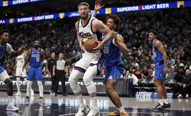 Sacramento Kings forward Domantas Sabonis, center left, works for a shot-opportunity as Dallas Mavericks' Kessler Edwards (20) defends in the first half of an NBA basketball game in Dallas, Monday, Feb. 10, 2025. (AP Photo/Tony Gutierrez)