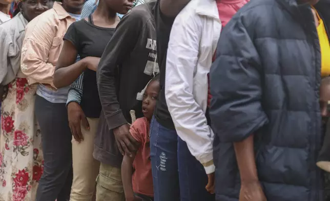 People line up to receive food at a shelter for families displaced by gang violence in the Kenscoff neighborhood of Port-au-Prince, Haiti, Monday, Feb. 3, 2025. (AP Photo/Odelyn Joseph)
