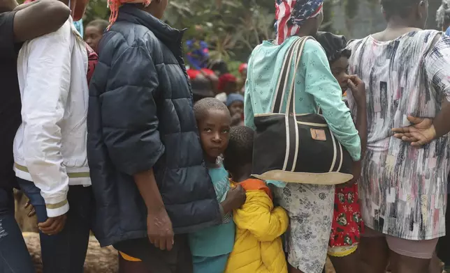 People line up to receive food at a shelter for families displaced by gang violence in the Kenscoff neighborhood of Port-au-Prince, Haiti, Monday, Feb. 3, 2025. (AP Photo/Odelyn Joseph)