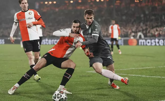 AC Milan's Santiago Gimenez, right, challenges for the ball with Feyenoord's David Hancko during the Champions League playoff first leg soccer match between Feyenoord and AC Milan, at the De Kuip stadium, in Rotterdam, Netherlands, Wednesday, Feb. 12, 2025. (AP Photo/Peter Dejong)