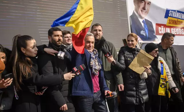 Calin Georgescu, the winner of Romania's first round of presidential election, annulled by the Constitutional Court, waves to supporters gathered for a protest outside the Romanian parliament in Bucharest, Romania, Saturday, Feb. 22, 2025. (AP Photo/Alexandru Dobre)