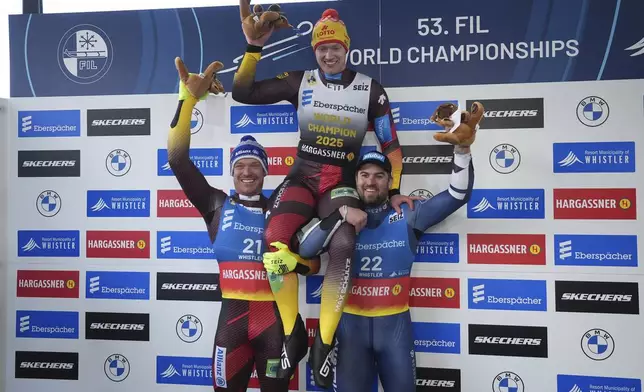 Germany's Max Langenhan, top center,, is hoisted by Germany's Felix Loch, left, who finished second, and Austria's Nico Gleirscher, who finished third, after Langenhan men's singles event at the Luge World Championships in Whistler, British Columbia, Saturday, Feb. 8, 2025. (Darryl Dyck/The Canadian Press via AP)
