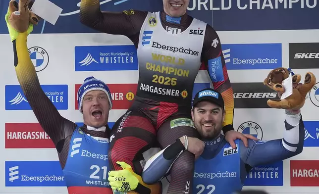Germany's Max Langenhan, top center, is hoisted by Germany's Felix Loch, left, who finished second, and Austria's Nico Gleirscher, who finished third, after Langenhan men's singles event at the Luge World Championships in Whistler, British Columbia, Saturday, Feb. 8, 2025. (Darryl Dyck/The Canadian Press via AP)