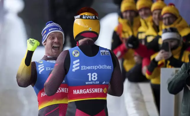 Germany's Felix Loch, back left, who finished second, celebrates with compatriot Max Langenhan after Langenhan won the men's singles event at the Luge World Championships, in Whistler, B.C., on Saturday, Feb. 8, 2025. (Darryl Dyck/The Canadian Press via AP)