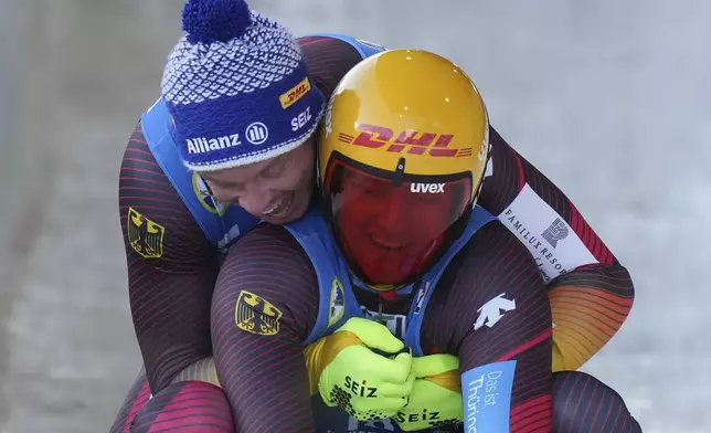Germany's Max Langenhan, front right, is congratulated by compatriot Felix Loch, back, who finished second, after Langenhan won the men's singles event at the Luge World Championships, in Whistler, B.C., on Saturday, Feb. 8, 2025. (Darryl Dyck/The Canadian Press via AP)