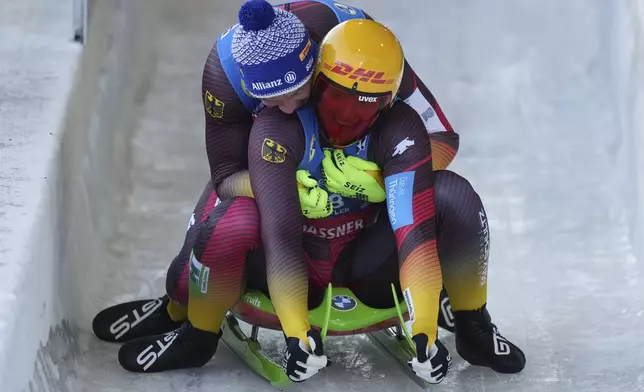 Germany's Max Langenhan, front right, is congratulated by compatriot Felix Loch, back, who finished second, after Langenhan won the men's singles event at the Luge World Championships, in Whistler, B.C., on Saturday, Feb. 8, 2025. (Darryl Dyck/The Canadian Press via AP)