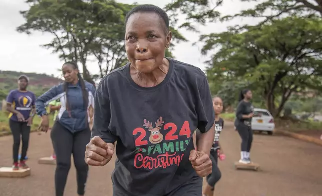 Mellisa Sachitongo, 65, exercises with the Commandos Fitness Club at the Warren Hills cemetery in Harare, Zimbabwe, Saturday, Jan. 18, 2025. ( AP Photo/Aaron Ufumeli)