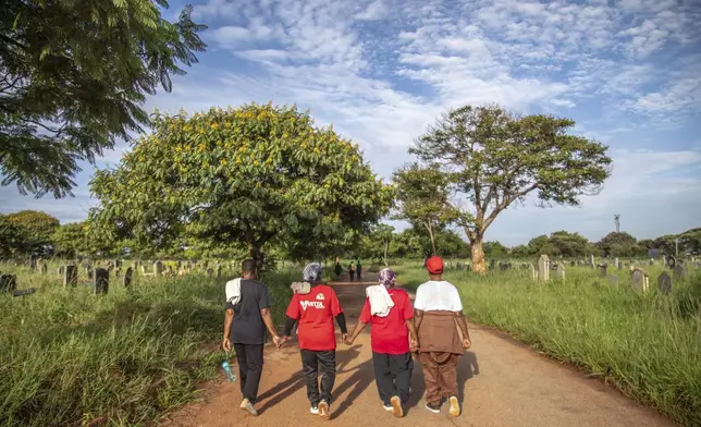 Women walk home after exercising with the Commandos Fitness Club at the Warren Hills cemetery in Harare, Zimbabwe, Saturday, Jan. 18, 2025. ( AP Photo/Aaron Ufumeli)