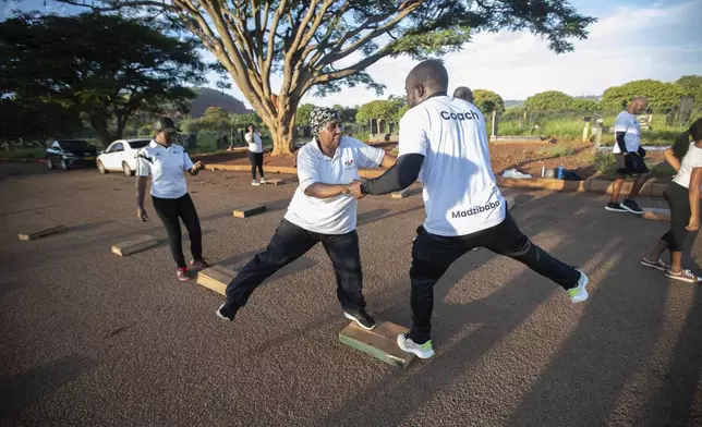 Susan Gomo, 65, exercises with the Commandos Fitness Club at the Warren Hills cemetery in Harare, Zimbabwe, Saturday, Jan. 18, 2025. ( AP Photo/Aaron Ufumeli)