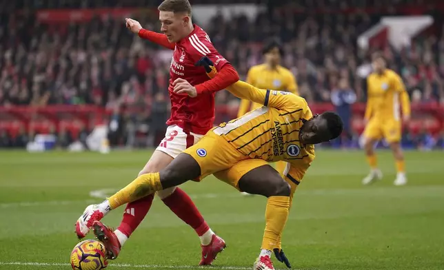 Nottingham Forest's Elliot Anderson and Brighton and Hove Albion's Yankuba Minteh, right, battle for the ball during the Premier League match between Brighton and Nottingham Forest at the City Ground, Nottingham, England, Saturday Feb. 1, 2025. (Martin Rickett/PA via AP)