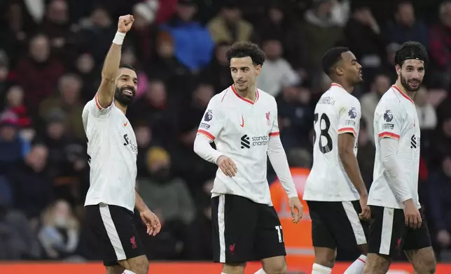 Liverpool's Mohamed Salah, left, celebrates with his teammates after scoring his side's second goal during the English Premier League soccer match between Bournemouth and Liverpool at the Vitality stadium in Bournemouth, England, Saturday, Feb. 1, 2025. (AP Photo/Alastair Grant)