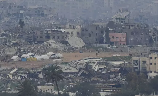 Palestinians are seen near destroyed buildings by Israeli bombardments inside the northern Gaza Strip as seen from southern Israel, Sunday, Feb. 9, 2025. (Photo/Ohad Zwigenberg)