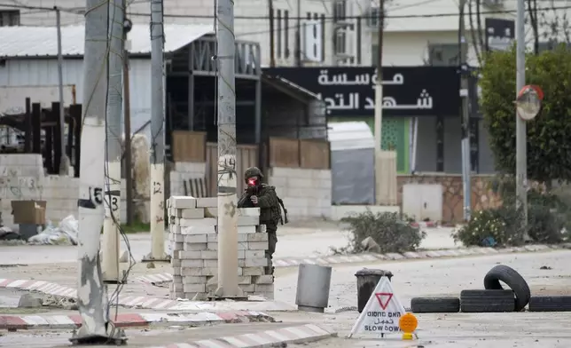 An Israeli soldier aims his weapon during a military raid in the West Bank refugee camp of Nur Shams, Tulkarem, Sunday, Feb. 9, 2025. (AP Photo/Majdi Mohammed)
