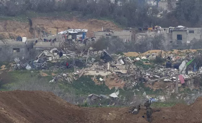 Israeli soldiers take positions near destroyed buildings inside the northern Gaza Strip as seen from southern Israel, Sunday, Feb. 9, 2025. (AP Photo/Ohad Zwigenberg)