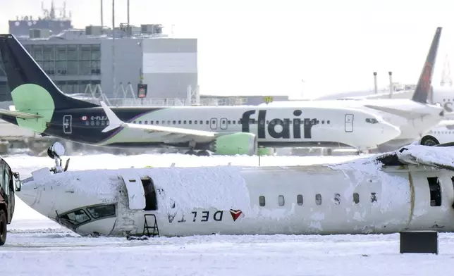 A Delta Air Lines plane lies upside down at Toronto Pearson Airport on Tuesday, Feb. 18, 2025. (Chris Young/The Canadian Press via AP)