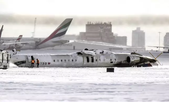 A Delta Air Lines plane lies upside down at Toronto Pearson Airport on Tuesday, Feb. 18, 2025. (Chris Young/The Canadian Press via AP)