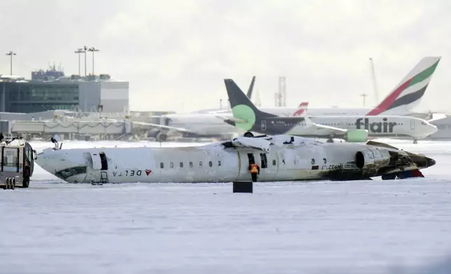 A Delta Air Lines plane lies upside down at Toronto Pearson Airport on Tuesday, Feb. 18, 2025. (Chris Young/The Canadian Press via AP)