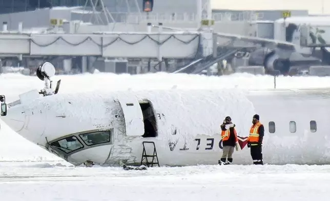 A Delta Air Lines plane lies upside down at Toronto Pearson Airport on Tuesday, Feb. 18, 2025. (Chris Young/The Canadian Press via AP)