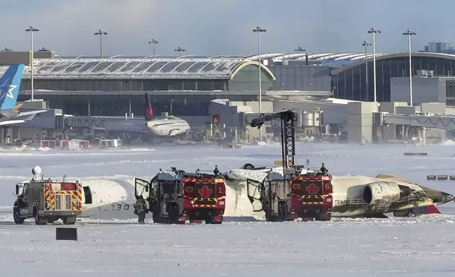 An aircraft from Delta Airlines sits upside down on the tarmac at Toronto Pearson International airport, Monday, Feb. 17, 2025. (Teresa Barbieri/The Canadian Press via AP)