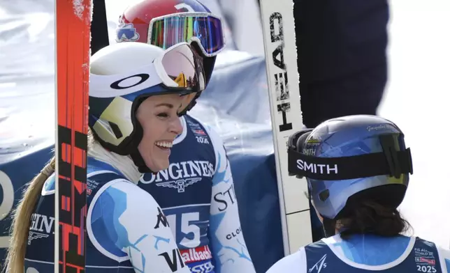 United States' Lindsey Vonn, left, talks to United States' Lauren Macuga and United States' Jacqueline Wiles, right, at the finish area of a downhill run of a women's team combined event, at the Alpine Ski World Championships, in Saalbach-Hinterglemm, Austria, Tuesday, Feb. 11, 2025. (AP Photo/Giovanni Auletta)