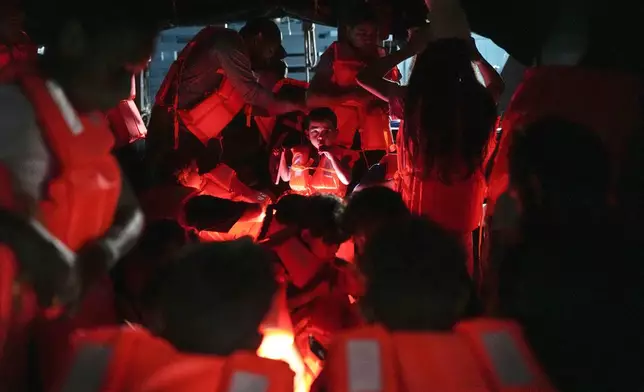 Migrants board a boat at the Caribbean coastal village of Miramar, Panama, bound for the Colombian border, Thursday, Feb. 27, 2025, as migrants return from southern Mexico after abandoning hopes of reaching the U.S. in a reverse flow triggered by the Trump administration's immigration crackdown. (AP Photo/Matias Delacroix)