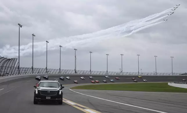 President Donald Trump rides in the presidential limousine known as "The Beast" as he takes a pace lap ahead of the start of the NASCAR Daytona 500 auto race at Daytona International Speedway, Sunday, Feb. 16, 2025, in Daytona Beach, Fla. (Chris Graythen/Pool via AP)