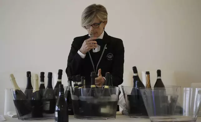 A sommelier opens Prosecco bottles during a wine testing in Asolo, Italy, Monday, Oct. 15, 2018. Global sales of prosecco the smooth, drinkable sparkling wine rooted in the northeastern hills of Italy are booming, and champagne, the original bubbly, is taking note. (AP Photo/Luca Bruno, File)