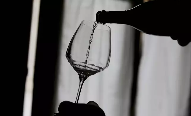Wine grower Adelino Pizzobon spills a bottle of Prosecco during a wine tasting at the Case Paolin farm, in Volpago del Montello, Italy, Monday, Oct. 15, 2018. (AP Photo/Luca Bruno, File)